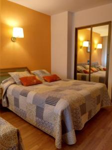 een slaapkamer met een bed en een grote spiegel bij Hotel Torres Guijuelo in Guijuelo
