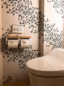 a bathroom with a toilet and a wall with a tree mural at Business Hotel Crescent in Tokyo