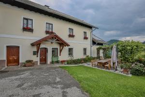 ein weißes Haus mit einem Hof mit einem Tisch und einer Terrasse in der Unterkunft Ferienhof Rabenreith in Grossraming