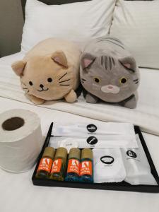 two stuffed animals sitting on a bed with rolls of toilet paper at Hotel Alpha in Bukit Mertajam