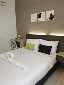 a bedroom with a large bed with white sheets and pillows at Hotel Alpha in Bukit Mertajam +32 photos