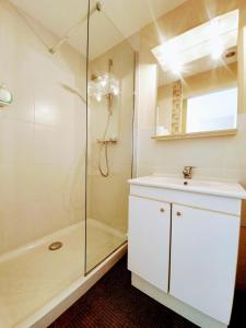 a white bathroom with a shower and a sink at Le Toul' Broch in Baden