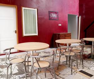 パダンにあるSPOT ON 2182 Al-ghani 2 Syariahの赤い壁にテーブルとスツールが備わる部屋