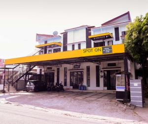 a store with a yellow sign on the front of a building at SPOT ON 2182 Al-ghani 2 Syariah in Padang