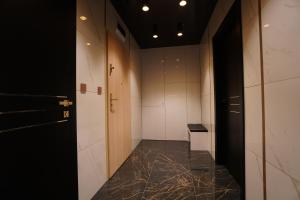 a hallway with white walls and a marble floor at Apartament Lema Versace in Kraków