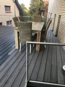 een houten tafel en stoelen op een terras bij Pension Asche in Münster