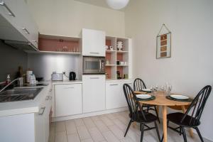 une cuisine avec une table et des chaises et une cuisine avec des placards blancs dans l'établissement Pour une escapade à Nantes, face au Musée d’Arts, à Nantes
