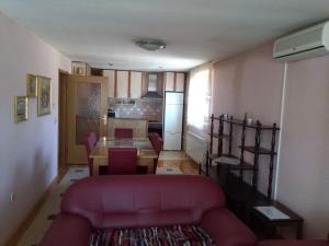 salon z czerwoną kanapą i stołem w obiekcie SARAJEVO-ADI APARTMENTS II w Sarajewie