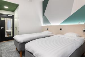 Dos camas en una habitación de hotel con una habitación en GreenStar Hotel Vaasa en Vaasa