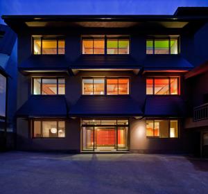 un edificio con ventanas iluminadas por la noche en Address Nozawa, en Nozawa Onsen
