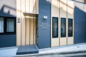 a front door of a building with a sign on it at IKIDANE Residential Hotel Komagome in Tokyo