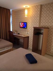 a hotel room with a desk and a bed and a television at Hotel Sri Sutra PJ 222 in Petaling Jaya