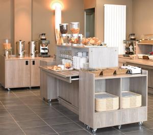 eine große Küche mit Tischen mit Essen drauf in der Unterkunft Park Hôtel & Appartements in Cholet
