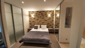 a bedroom with a bed and a brick wall at Old Riga Modern Apartment in Riga