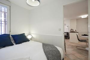 białe łóżko z niebieskimi poduszkami w pokoju w obiekcie LEEWAYS APARTMENT I in SAN LORENZO w Madrycie