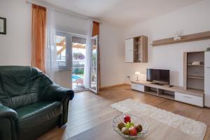 een woonkamer met een bank en een fruitschaal bij Apartment Twisting By The Private Pool in Zadar