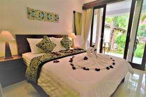 a bedroom with a bed with a flower decoration on it at BatanTop Ubud guest house in Ubud