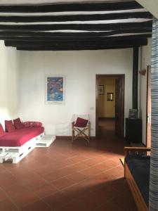 a living room with a red bed and a chair at Country Lodge MoniGio in Quattro Pani