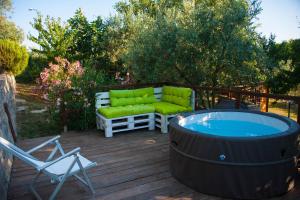 bañera de hidromasaje en una terraza con sofá y silla en Dimora nel Chianti en San Sano