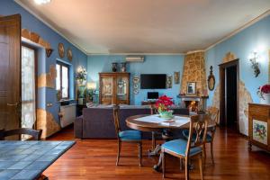 uma sala de estar com paredes azuis e uma mesa e cadeiras em Ai confini dell Etna 2 em Nunziata
