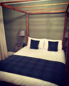 uma cama com um cobertor e almofadas azuis e brancas em The Carrick em Portrush