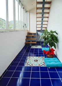 Habitación con suelo de baldosa azul y maceta. en Elpidios Galatro Terme, en Galatro