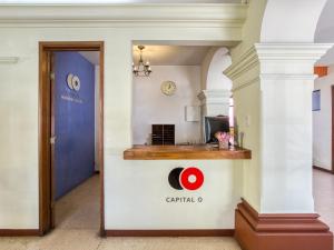 Un couloir dans un bâtiment avec un panneau indiquant la capitale o dans l'établissement Capital O Parador Crespo Hotel, Oaxaca, à Oaxaca