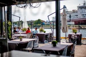 people sitting at tables in a restaurant with a cruise ship at Old Riga Modern Apartment in Riga