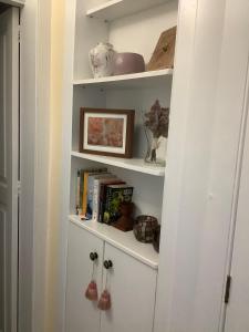 a white book shelf with books and other items on it at Casa Toledo in Las Palmas de Gran Canaria