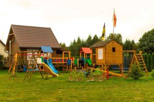 a playground with a house and a play yard at Domki letniskowe w Kopalinie in Kopalino