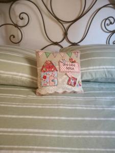 a pillow with a house on a bed at Romantic loft in Pitigliano
