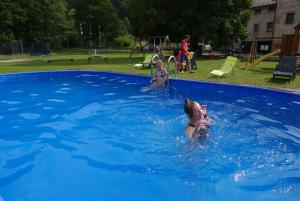 Stárkov的住宿－綠谷公園度假屋，一群儿童在游泳池玩耍
