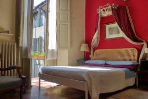 a bedroom with a bed with a red wall at Cozy apartment in Palazzo Malaspina in Piacenza