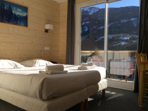 ein Schlafzimmer mit einem Bett und einem großen Fenster in der Unterkunft Hôtel Cristol in Briançon