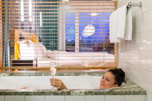 a woman in a bathtub holding a glass of champagne at Hotel Rival in Stockholm