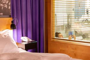 a girl is looking out the window of a bedroom at Hotel Rival in Stockholm