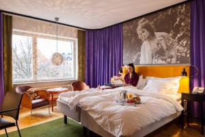 a woman sitting on a bed in a hotel room at Hotel Rival in Stockholm