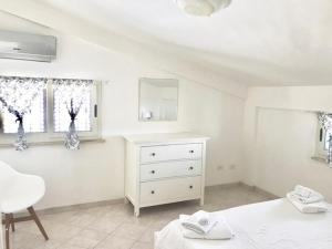Habitación blanca con vestidor y ventana en Villa Oasi di Vendicari, en Marzamemi
