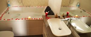 a bathroom with a sink and a tub and candles at Pompeii Ruins De Charme B&B in Pompei