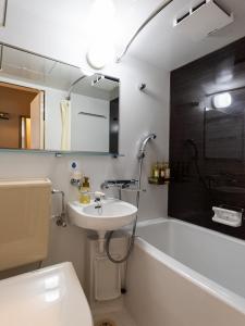 a bathroom with a sink and a bath tub at Hotel Etwas Tenjin in Fukuoka
