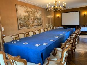 une salle de conférence avec une grande table, des chaises et un écran dans l'établissement Château Des Bondons EI, à La Ferté-sous-Jouarre