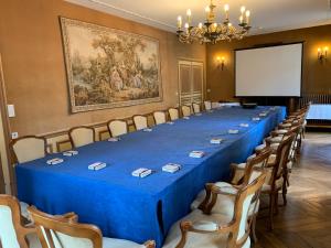 una sala de conferencias con una mesa larga con sillas y una pantalla en Château Des Bondons EI, en La Ferté-sous-Jouarre