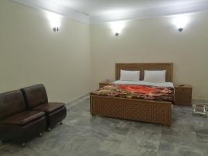 Star Hotel Lahore في لاهور: غرفة نوم بسرير وكرسي