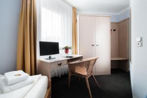 a hotel room with a bed and a desk with a computer at Hotel Zum Eisenhammer in Oberhausen