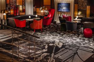 a lobby with red chairs and a painting on the floor at Hotel Rival in Stockholm