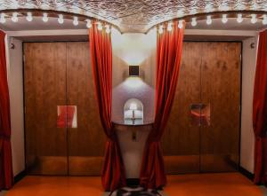 a room with red curtains and a mirror at Hotel Rival in Stockholm