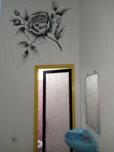 uma casa de banho com um mural de flores na parede em The Mel Homestay em Nusa Penida