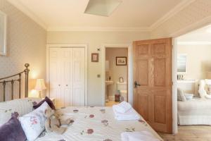 a teddy bear sitting on a bed in a bedroom at Gardeners Cottage in Bridport