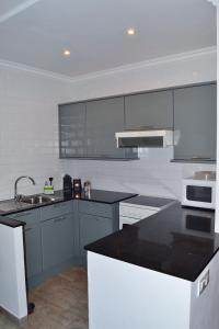 a kitchen with gray cabinets and a black counter top at Girasols Garden 3 in Son Bou