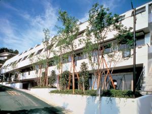 a white building with trees in front of it at The Gran Resort Elegante Atami in Atami